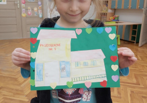 Dziewczynka pokazuje rysunek Przedszkola nr 7